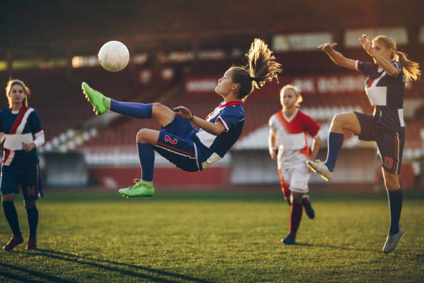 Photo of a girl jumping to kick a ball